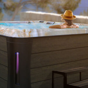 Woman wearing a hat looking relaxed in a hot tub.